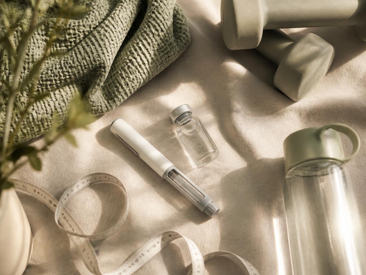 An unbranded treatment pen and vial laid out with training gear